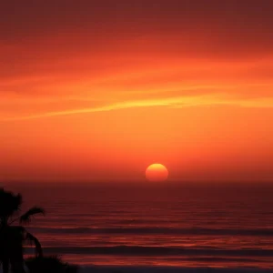 A stunning hazy sunset at Hilton Head, featuring vibrant red colors in the sky and serene ocean waves.