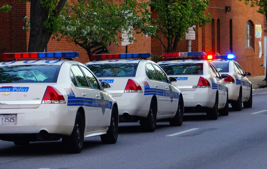 Police car with lights along a roadside