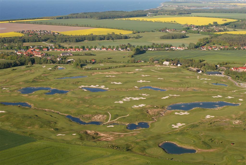 Green golf course fairway with trees and sand bunkers